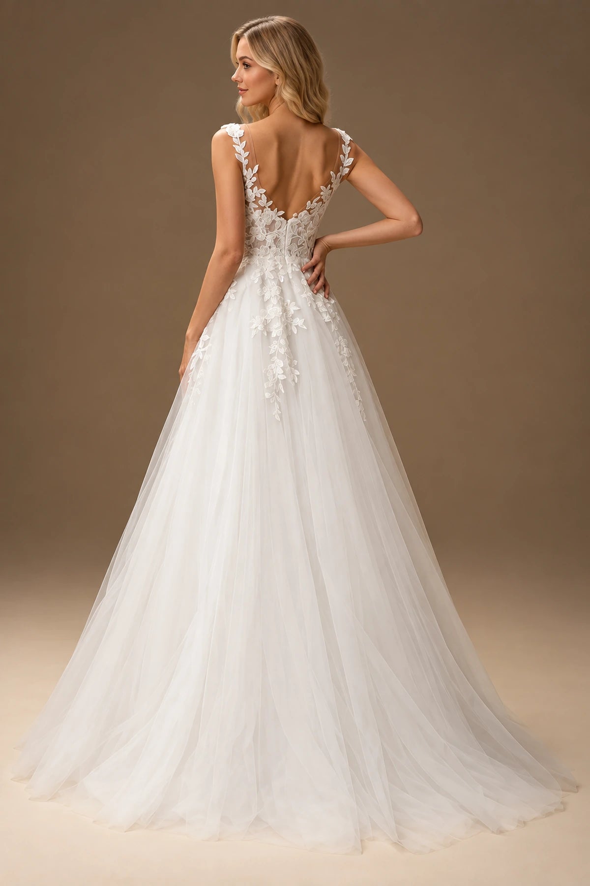 Back view of Vedress A-line wedding dress with a deep U-shaped low back, leaf-trimmed straps and a softly trailing skirt.